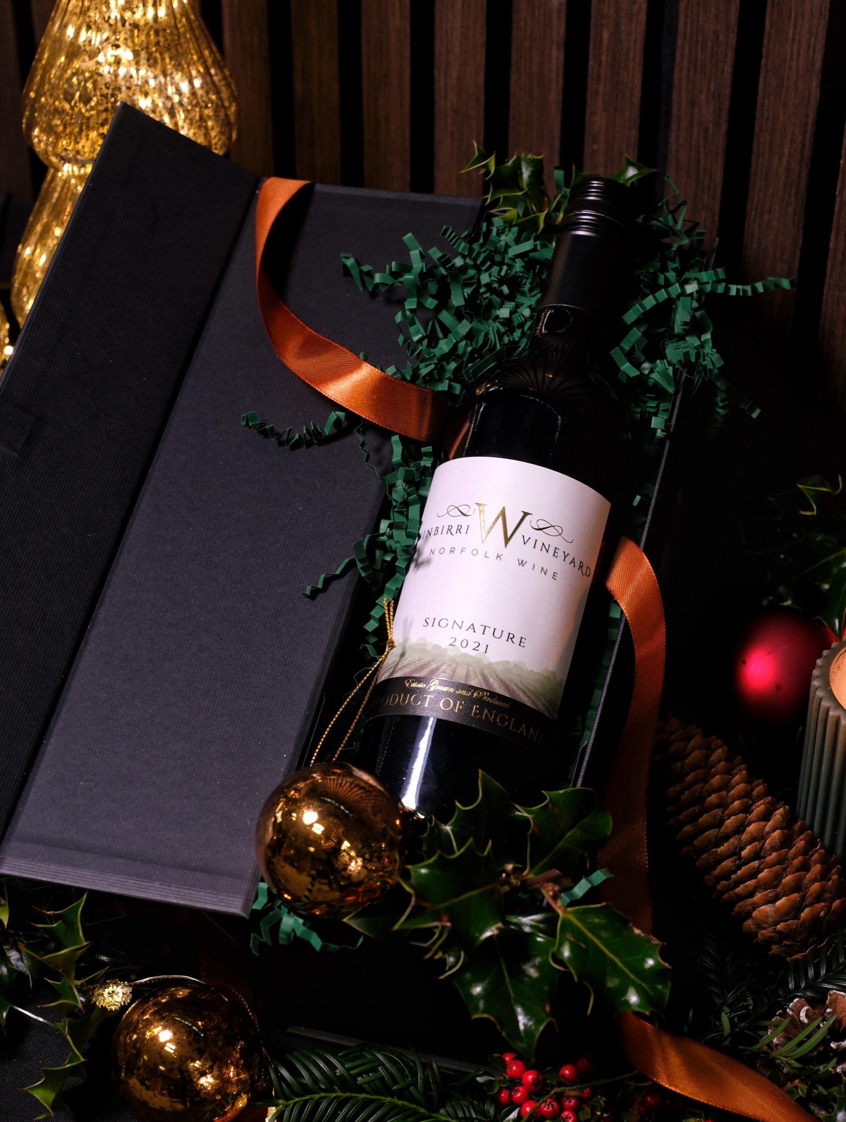 Bottle of Norfolk red wine tied with copper ribbon in a black presentation box