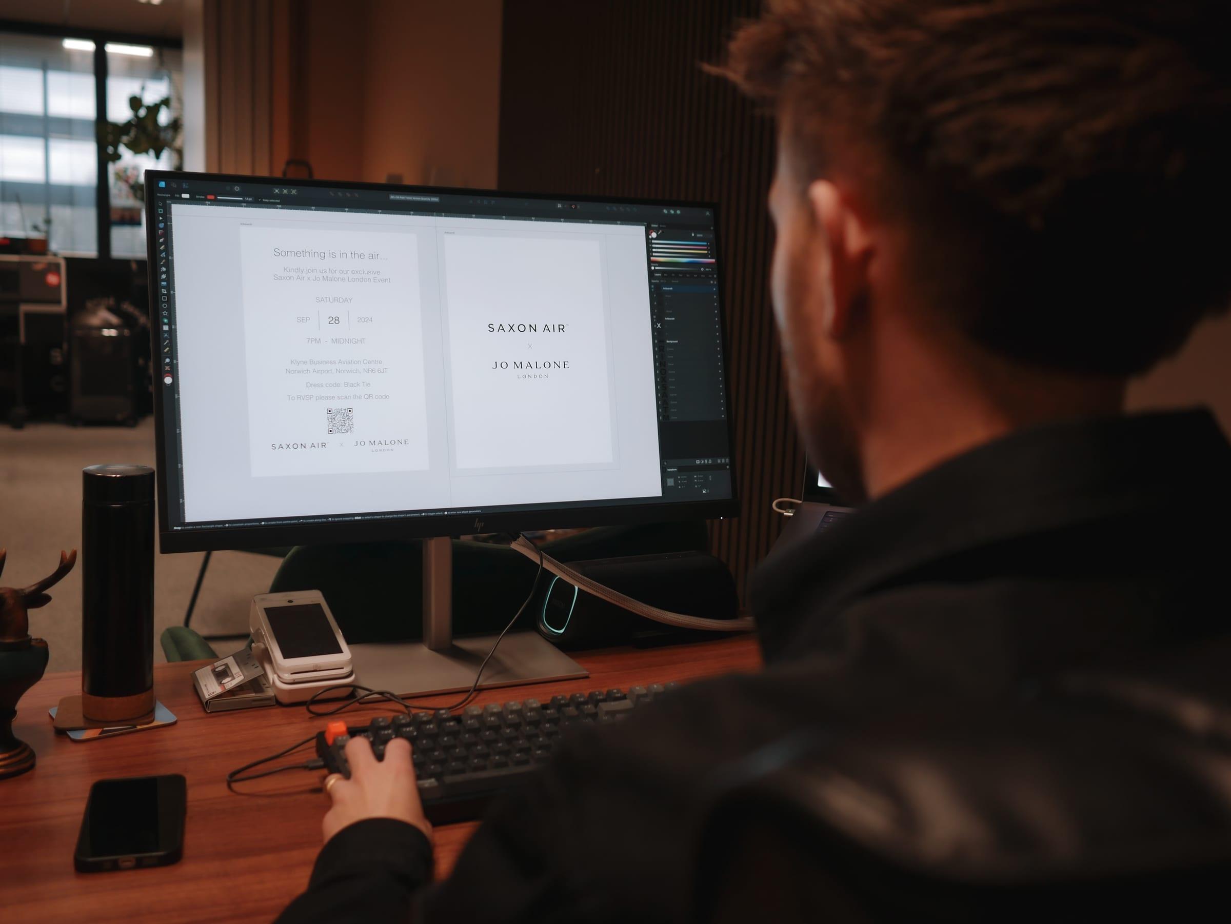 Designer laying out print artwork on a monitor in the Merch Hive studio