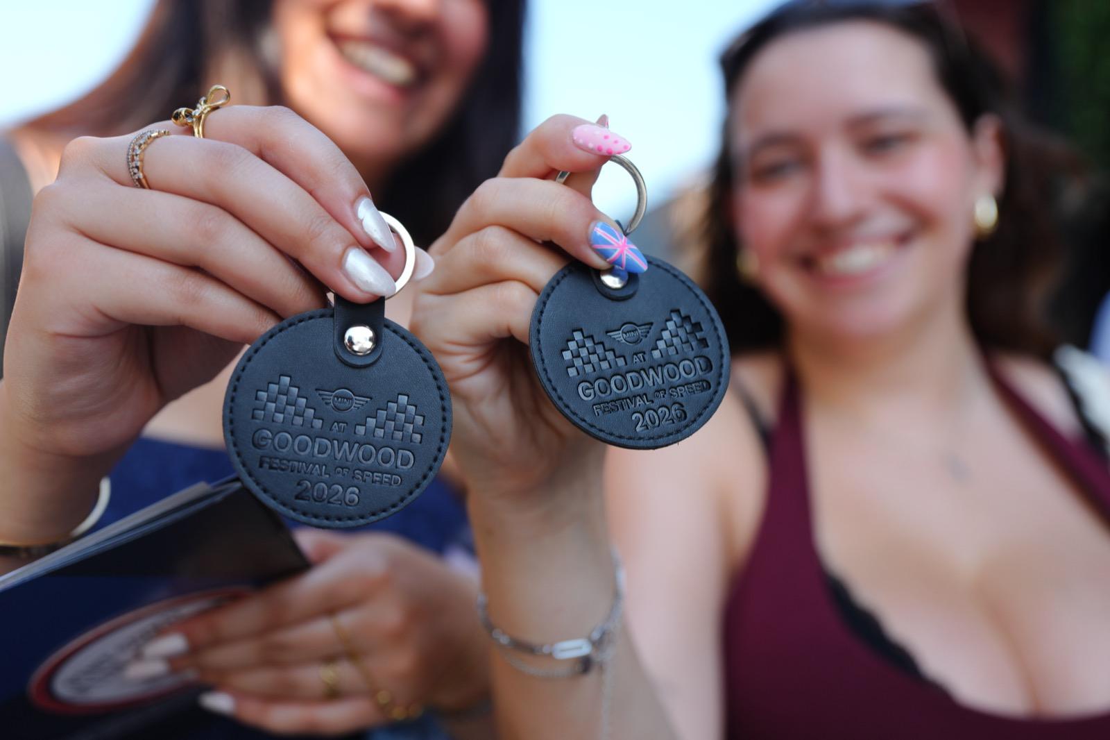 Two guests holding up their freshly embossed Goodwood keyrings